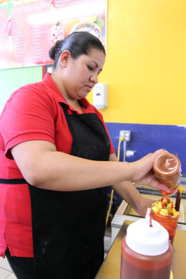 Worker at Tocumbo Paleteria y Neveria makes a mangonada. This is a popular snack among students.