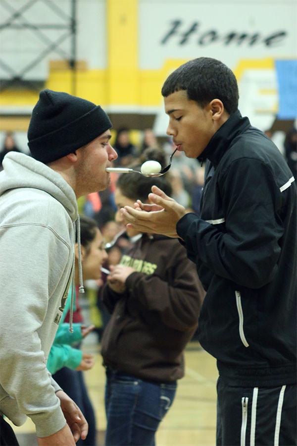 Junior Kevin Johnson passes the egg onto junior James Greens spoon in a race against other competitors.