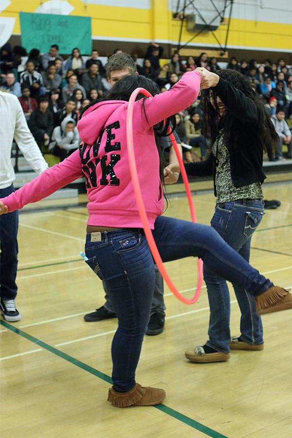 Participants rush to pass the hula hoop before the music stops in order to go onto the next round. 