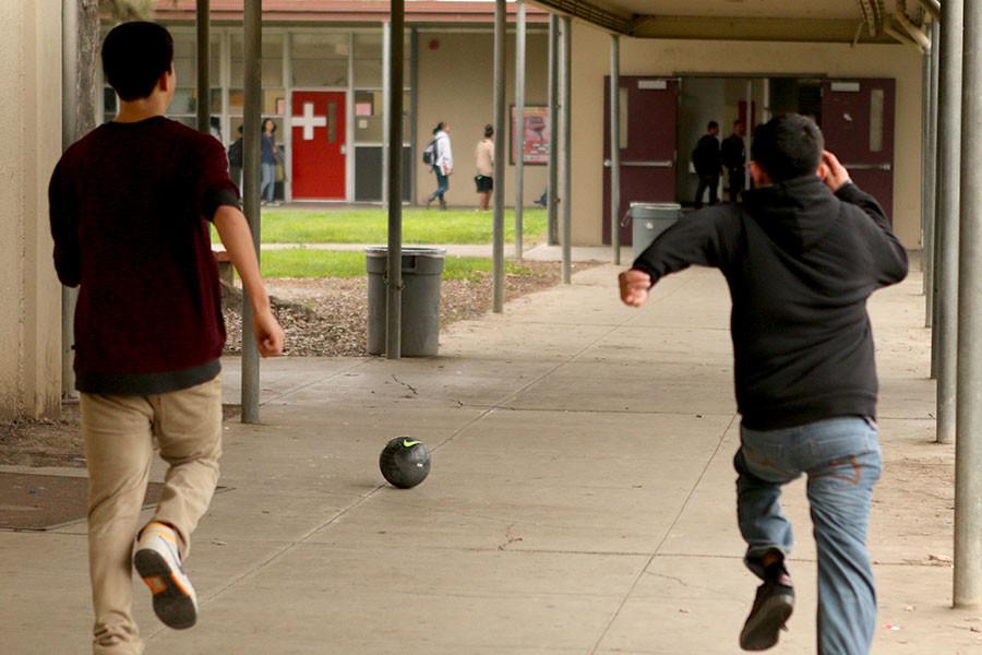 Students race for the ball during a game of soccer. 