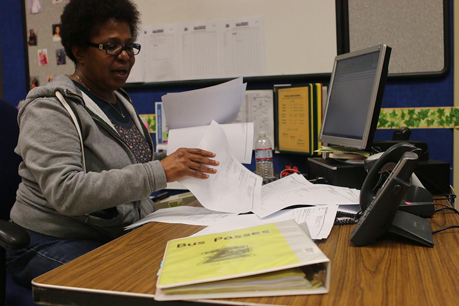 Sandra Johnson, the textbook clerk, goes through the many emails she has received from district transportation of students that dont qualify for a free bus pass while the binder contains those who do.