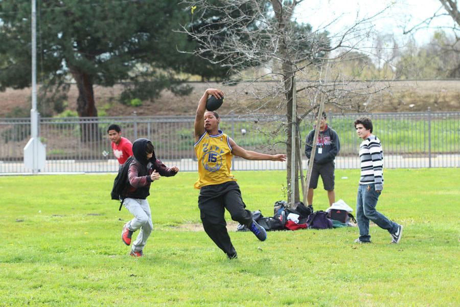 Students play a game of football at lunch.