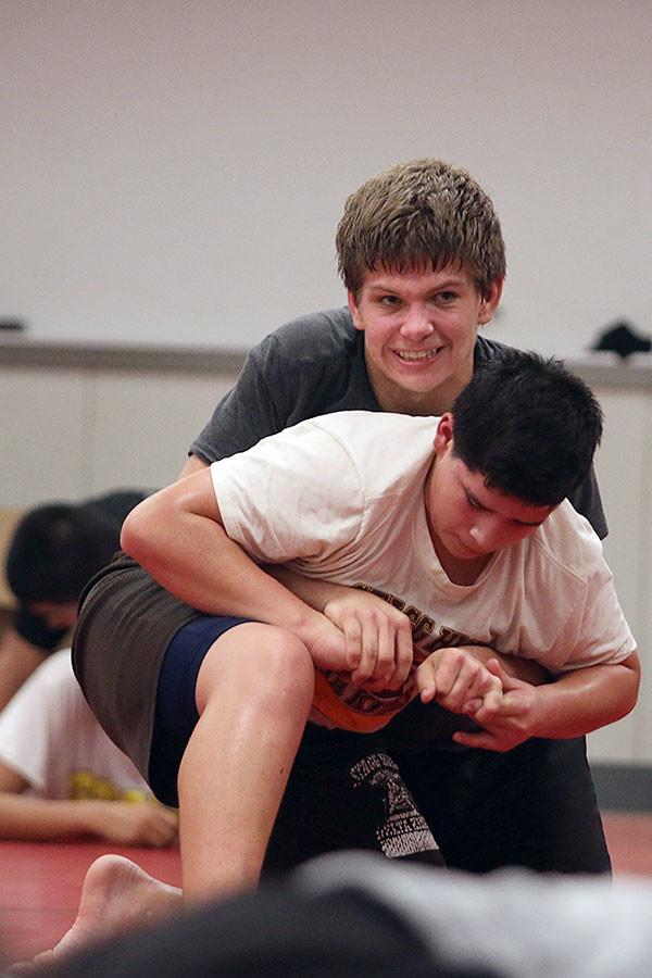During practice, wrestler Darryn Penry attempts to hold his grip as teammate Leo Leon grabs his fingers in a scurry to escape.