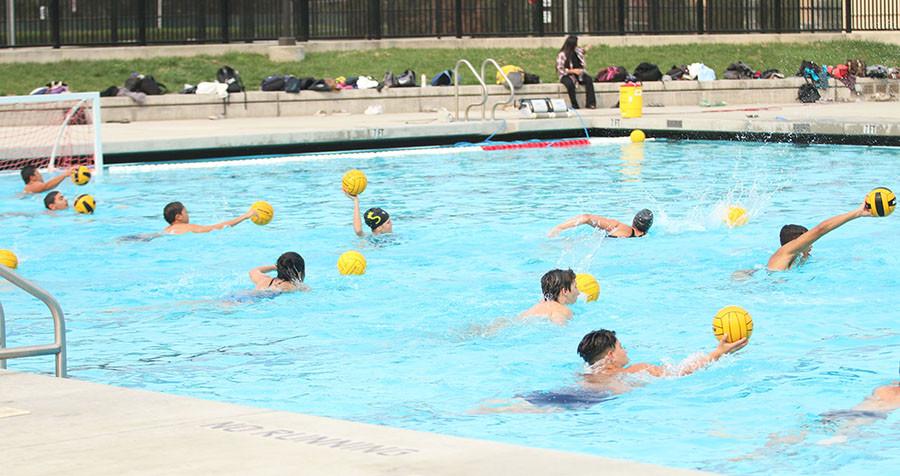 Boys and girls water polo team practice using proper  ball handling skills while swimming.