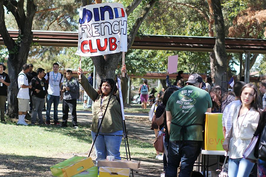 Senior Ebony Gonzales hold a sign trying to get students to sign up for french club.