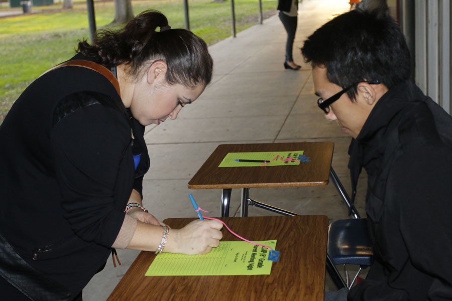 Students and families sign in before entering a classroom for a counselor presentation. 