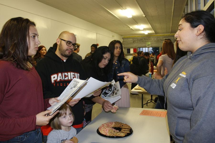 Christina Martinez, senior, informs a family about the AVID program, one of the many college prep electives on campus.
