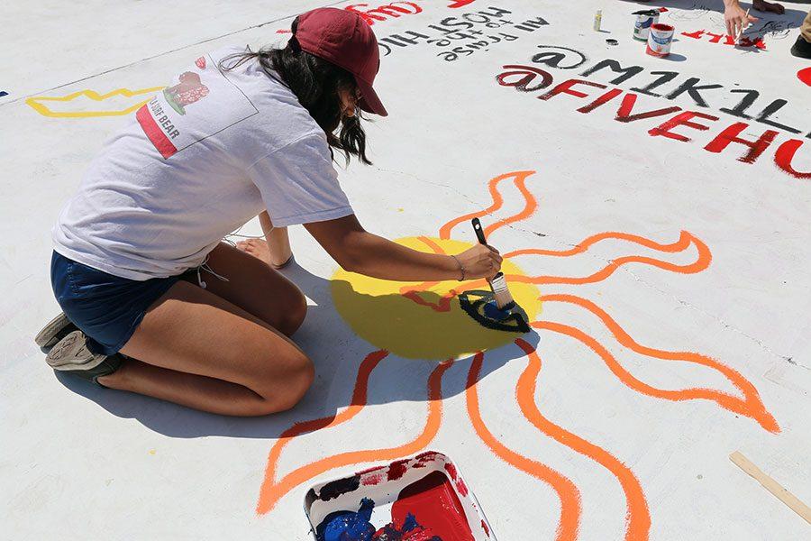 Sarai Cobos paints a sun and finishes it off with the phrase Dont Be Afraid 2 Shine.