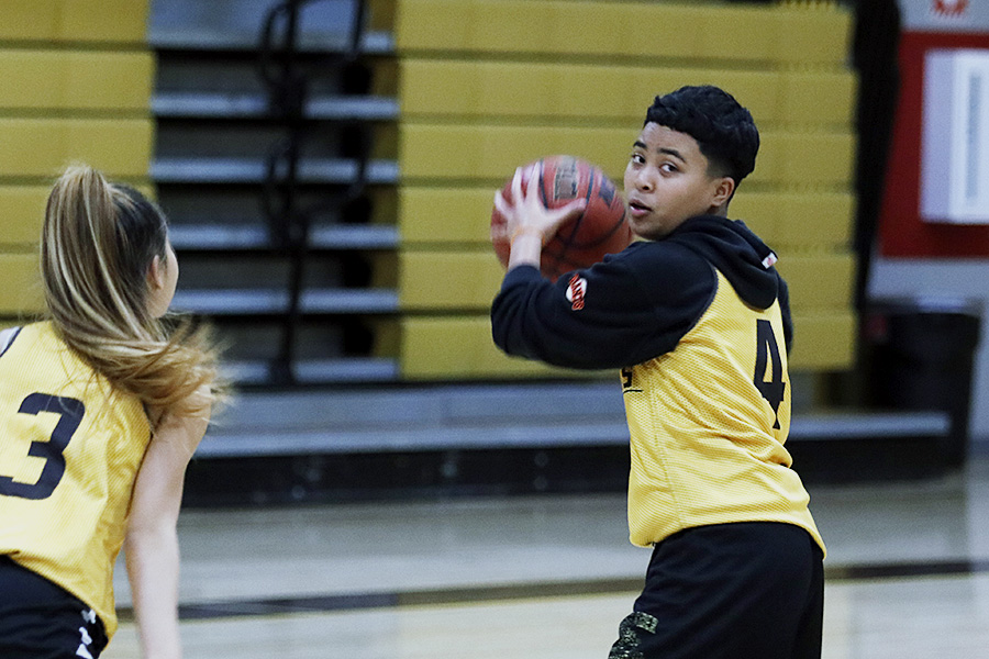 Sophara Khen, sophomore, looks around for her other teammates while junior Amy XXX attempts to block her during a drill at their practice.