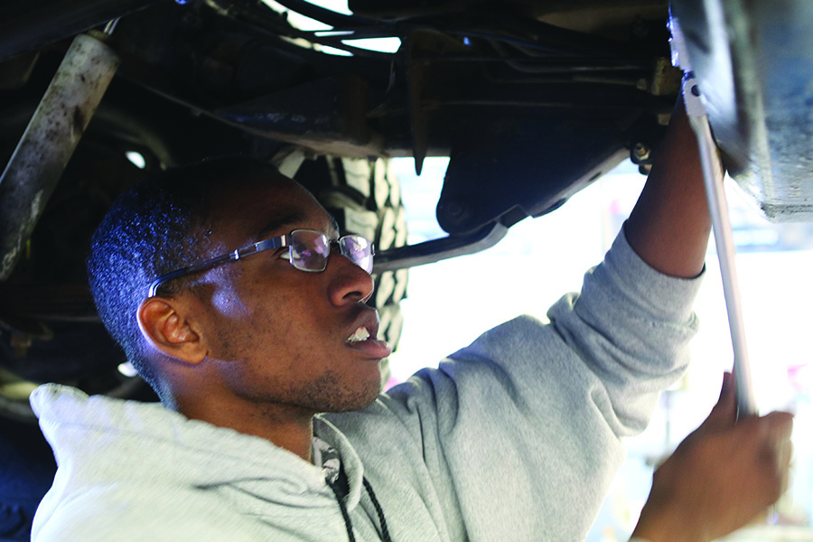 Senior Tyler Applon untightens the bolt to check the transmission fluid of a 1992 Safari Jeep. He ends up needing to fill it up with more fluid. He practices what he wants to do in his second period class Auto Tech which is taught by Jim Griffon.