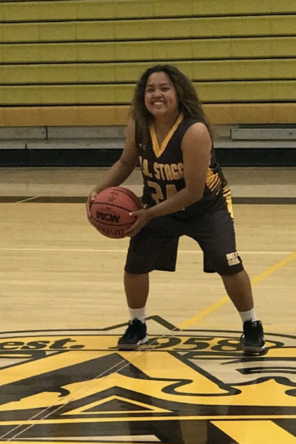 During winter sports team picture day, Aliyaah Mercado, senior, poses for the last time. Despite the many losses the team endured, Mercado kept her head high.
