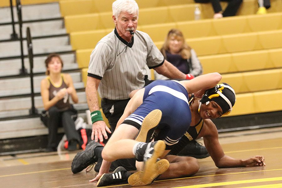 Senior Fredderick Shaddai changes his position to escape the pin. Looking for anyway out.