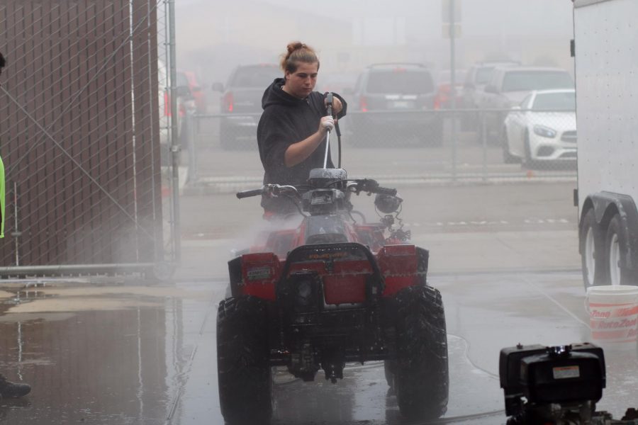 Student Phillip Castaneda washes down class four wheeler.