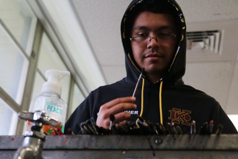 Senior Christopher Ramos looks for the best brushes, so he can make the best artwork possible.