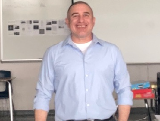 English teacher, Victor Castaneda poses for a picture in his classroom