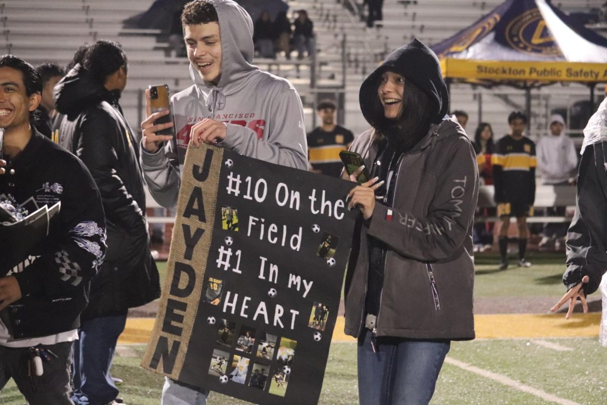 Wanting to show their appreciation, Joness friends hold up a poster to congratulate him on the winning game.  
