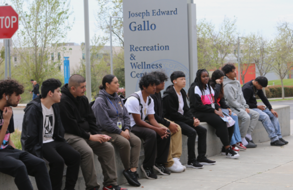 AVID 11 teacher,Sandra Ozornio-Caballero, and her group of students sit outside the  Recreation and Wellness center. Both groups were welcome to shop in the merch shop after the tour. 