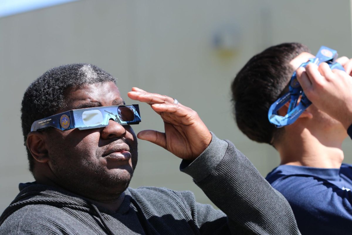 Aaron Ferguson (left) and a student use district provided glasses while safely watching the Solar eclipse. The glasses were provided by the district. 