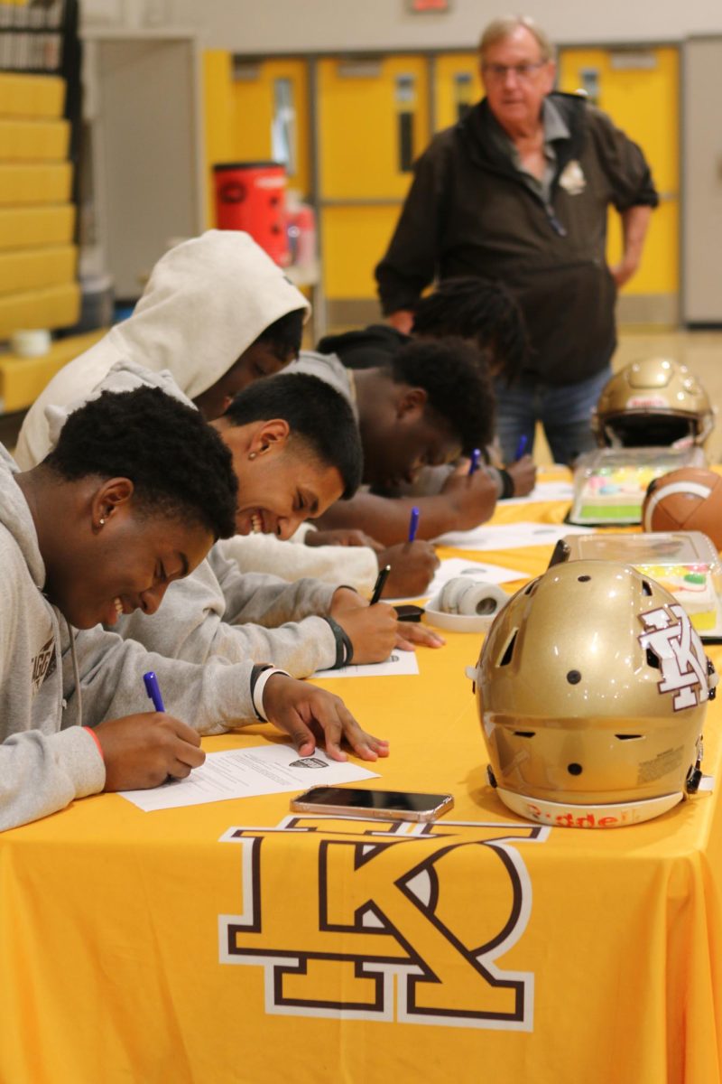 The athletes signing their contracts.