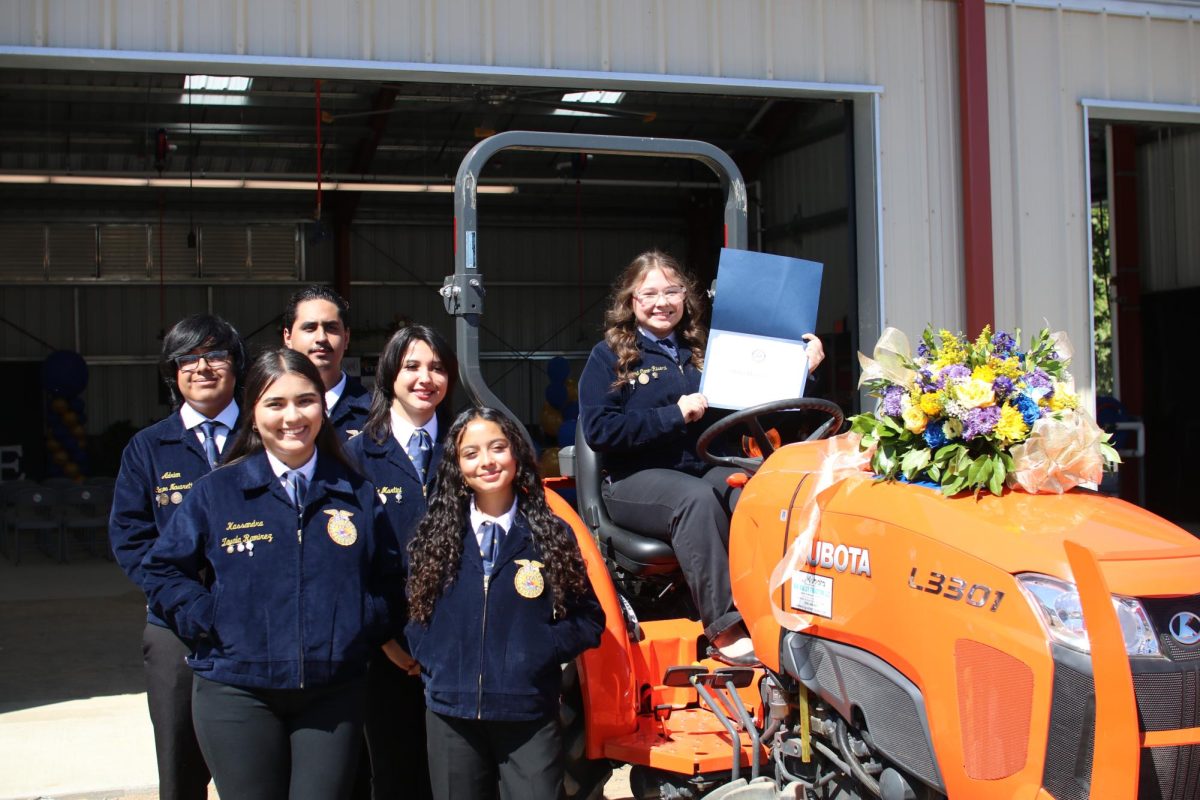 FFA President Reina Cano-Rivera holds the SUSD Recognition award together with other FFA officers. The flower arrangement atop the tractor was made by Stagg's Floral 3 class, who also made all the other arrangements seen at the ceremony. 