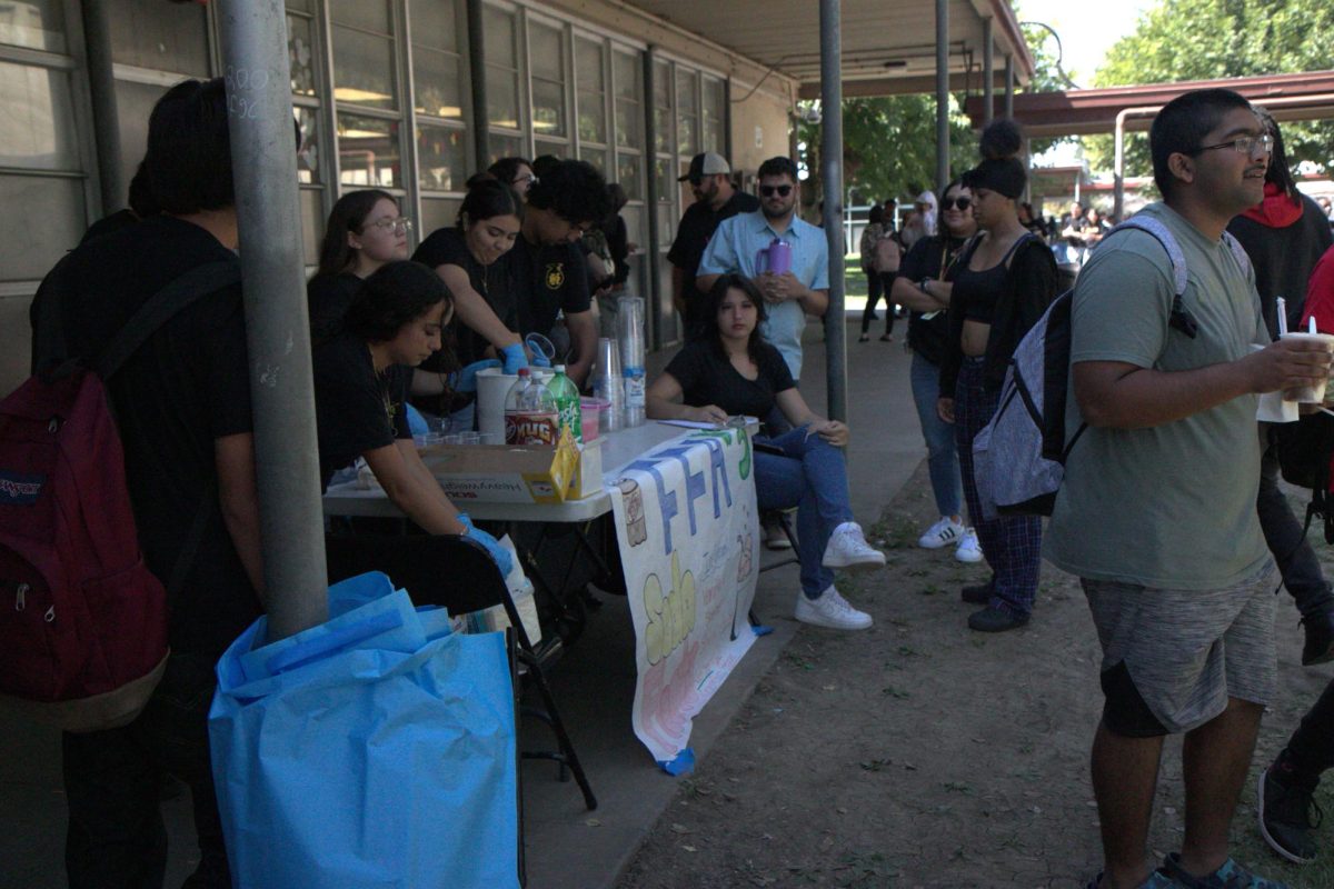 FFA Selling Soda floats For 3 dollars during Club rush. Kassandra Zavala, scooping ice cream into a cup for customer.