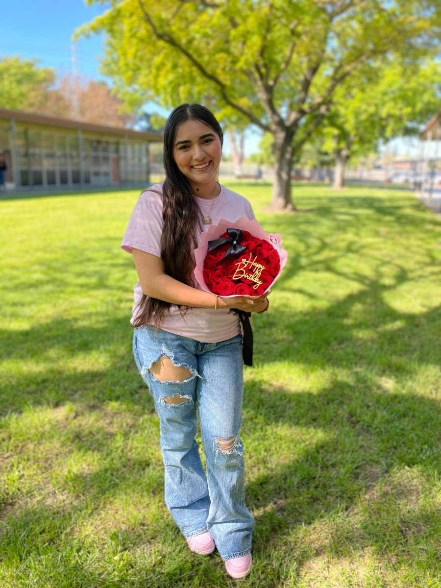 Kassandra Ramirez, senior, poses with a bouquet that she made for a customer. Ramirez also wears a shirt she designed to promote her business that says “In My Florist Era” with her business Instagram name (@KassandrasBouquets).