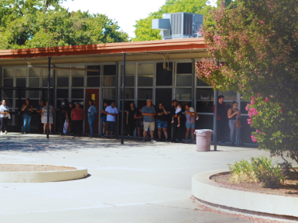  Dozens of parents and guardians wait outside the front office on Friday during lunch. A threat that was proven false raised concerns about students safety. 
