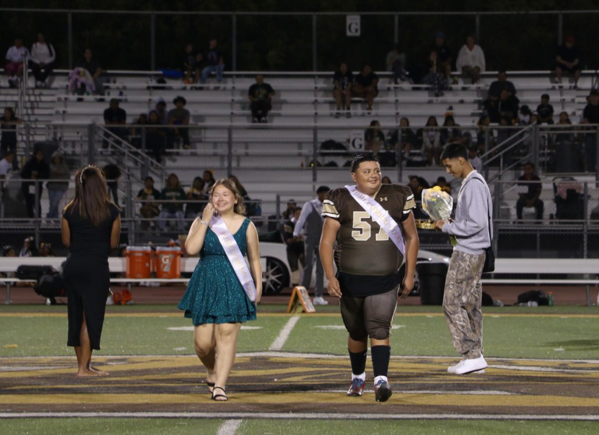 Nominees Reina Cano Rivera and Elias Rodriquez walk out with smiles on their faces after being introduced. During the halftime show, the crowning ceremony occurred on the football field.