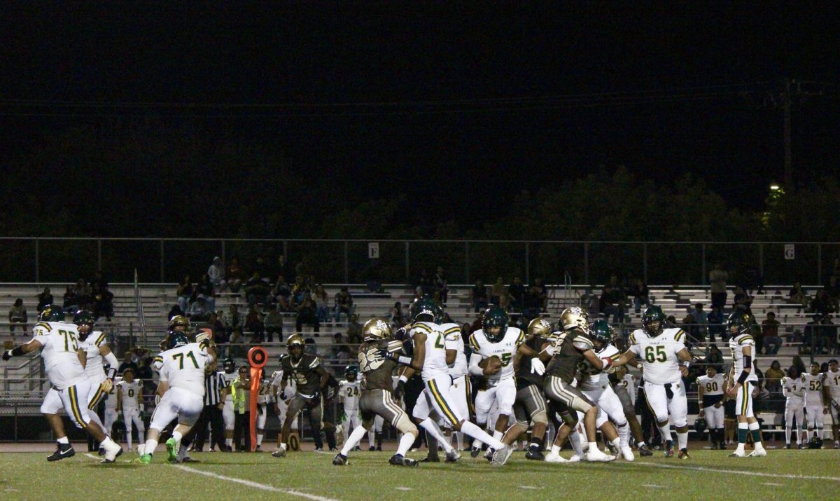 The Varsity football team defends in the middle of the first quarter of the homecoming game, while Franklin has possession of the ball.