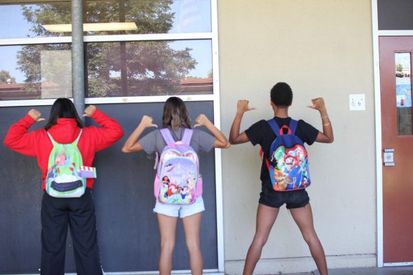 Seniors Cody Ayers, Aerie Garcia and  Tatianna Nagrete show off their kids backpacks. Ayers wears a Super Mario backpack, Garcia is wearing a Disney Princess backpack, and Nagrete wears a Buzz Lightyear inspired backpack