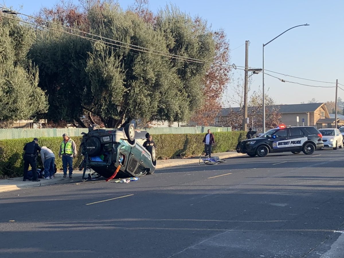 A photo of the scene where a Honda CR-Flipped over on Rose Marie Lane on Wednesday morning Dec 4. Police vehicles with officers on the scene were seen helping victims of the crash. (Ruben Manabat / Stagg Online)
