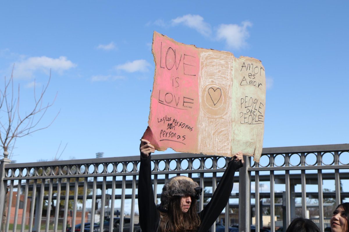 10th grader Issac Velez holds up a sign as he walks with fellow students to the bus stop. He proudly displays his support for human rights.