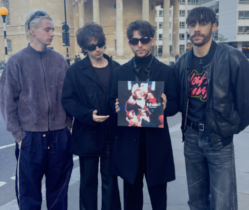 Irish Band Inhaler poses outside while showing off their record of their new album ¨Open Wide¨. Bassist Robert Keating (left), Eli Hewson (Center), drummer Ryan McMahon holding the Open Wide record, and guitarist Josh Jenkinson (right). (©Inhalerdublin on X)