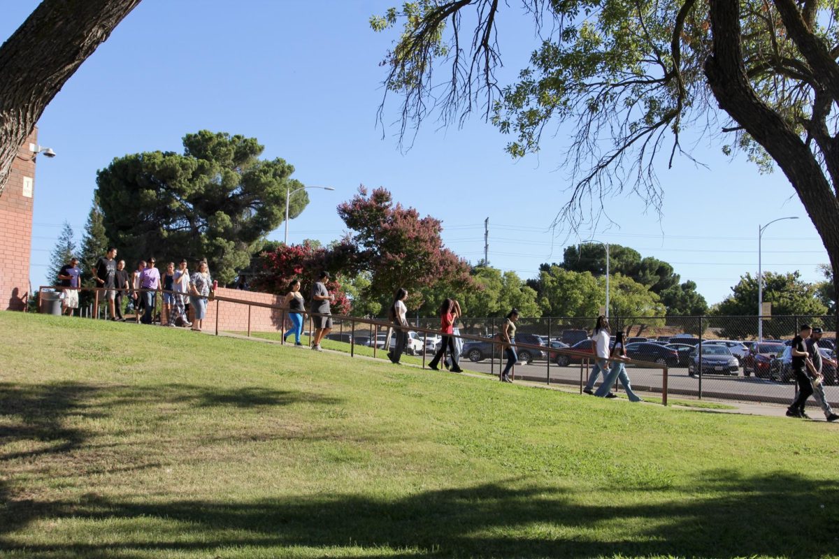 Parents and students alike head outside the theatre. They are leaving after a parent conference.
