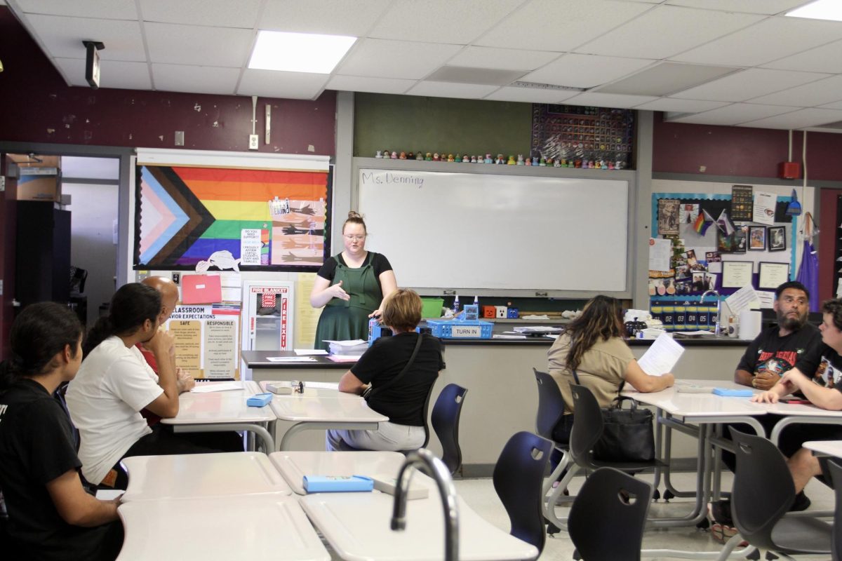 Chemistry teacher Ms. Dennings is seen talking to students and teachers. She is currently explaining her grading system.