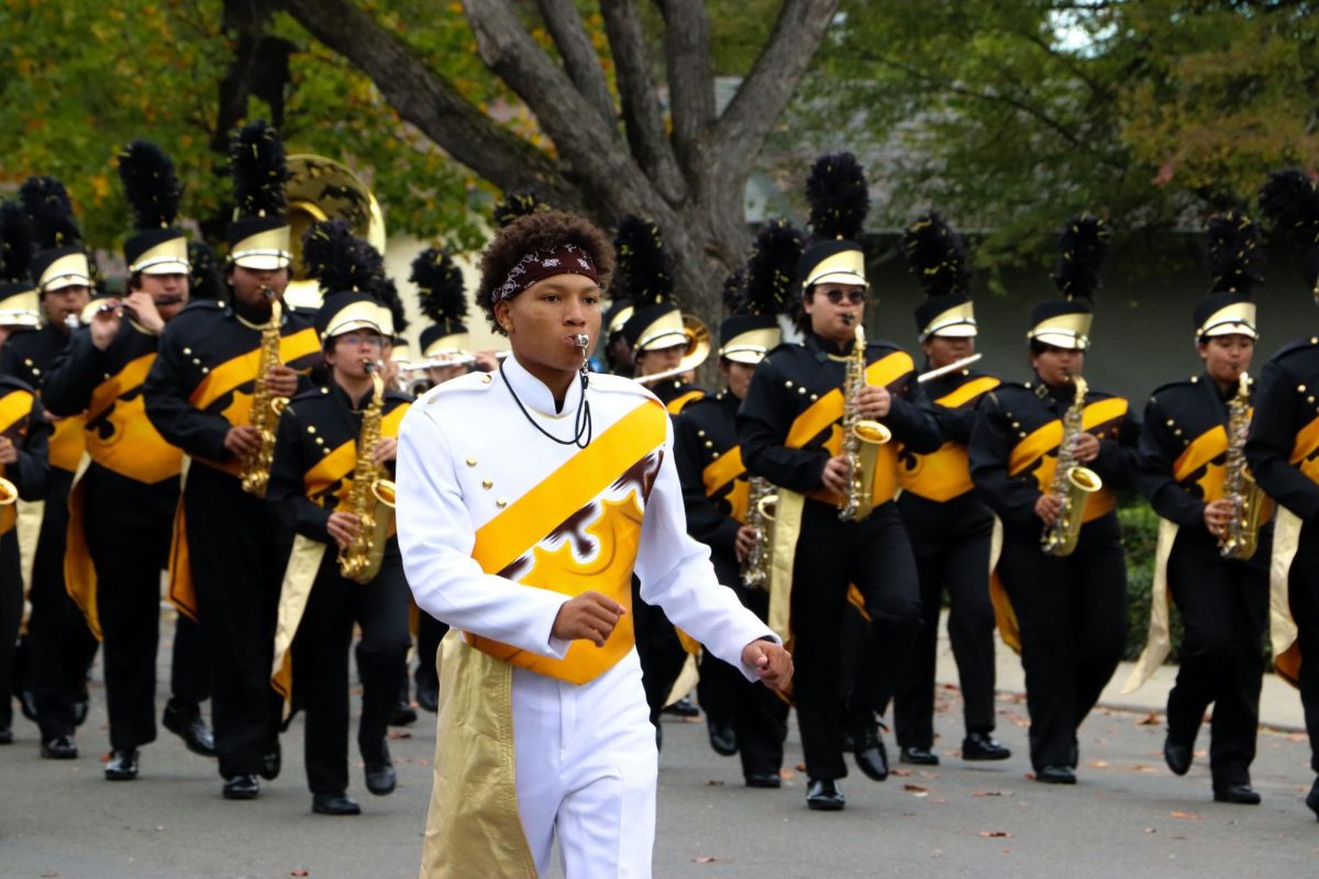 Drum Major Ciahjerrious Freeman-White (12) leads the band as they march, blowing the whistle to lead the march.
