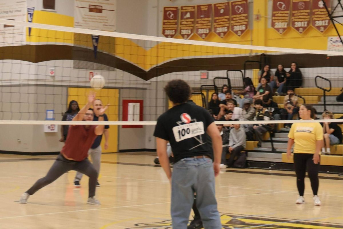 Math teacher David Magana receives the volleyball as it flies over the net.